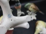 trois oiseaux perchés au sommet d'un vase