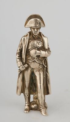 silver figurine of a man wearing a hat and coat