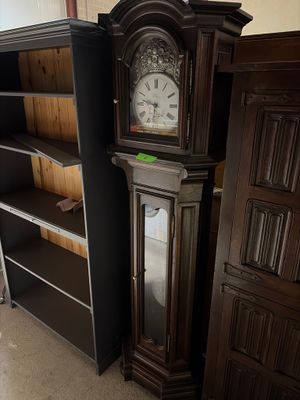 une horloge de parquet dans un coin de la pièce, à côté d'une bibliothèque