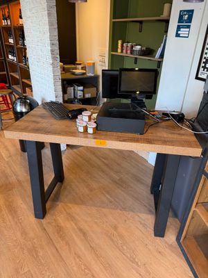 une table en bois sur laquelle est posé un ordinateur portable, dans une pièce