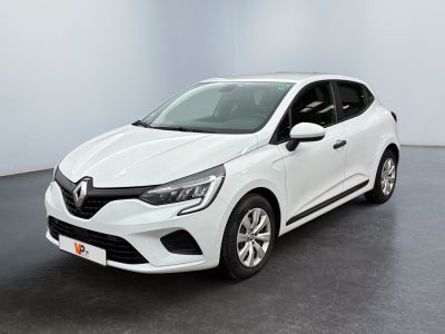 Une voiture blanche est garée dans une pièce au sol noir.