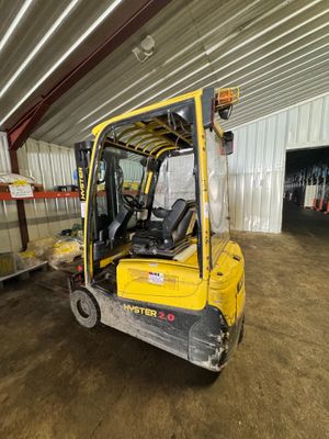 un chariot élévateur jaune garé à l'intérieur d'un bâtiment