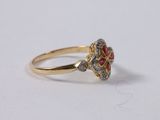 a close up of a gold ring with red and white stones