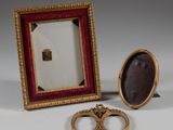 pair of gold wedding rings and a picture frame on a table