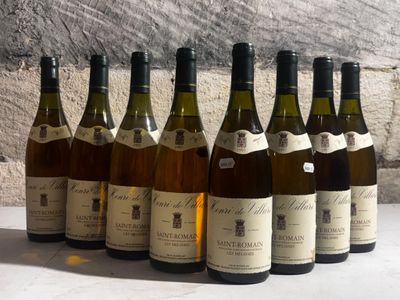 six bottles of wine are lined up in a row in front of a stone wall