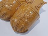 three brown vases sitting on a white surface