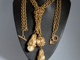 un gros plan d'un collier sur un mannequin, avec une chaîne