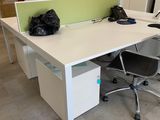a white desk with two chairs and a black bag on it