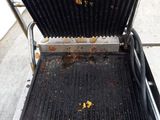 a grill that has a grill on it on the sidewalk