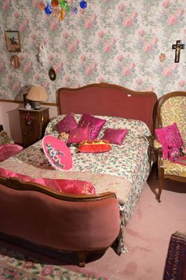 un lit et une chaise dans une pièce dont l'un des murs est recouvert de papier peint