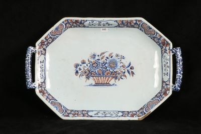 a blue and white plate with a basket of flowers on it