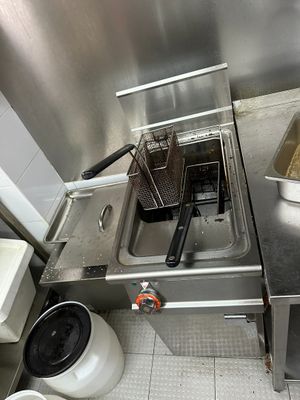 a small kitchen with a deep fryer and a sink