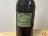 une bouteille de vin posée sur une étagère en bois