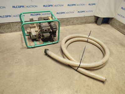 a hose and a pump on the floor next to a wall