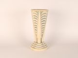 a white vase sitting on a table with a white wall in the background
