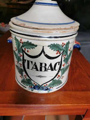 a ceramic container with a lid sitting on a wooden table