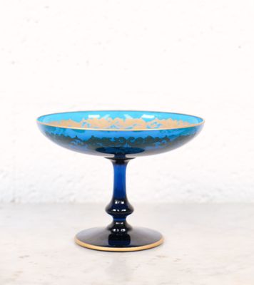 une image représentant un bol en verre bleu posé sur une table