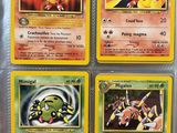 four pokemon cards are in a plastic case on a table