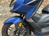 a blue scooter parked on the side of the road