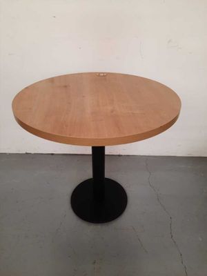 a round wooden table with a black metal base