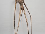 une sculpture en bronze représentant une femme debout sur un sol en damier