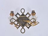 a clock on the wall with two candles and a candle holder