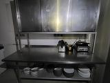 a large stainless steel kitchen counter with dishes on it