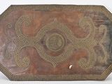an old wooden tray with a design on it on a white surface
