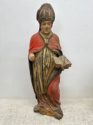 une statue représentant un homme tenant un livre entre ses mains
