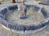 une statue représentant un homme tenant un oiseau dans un anneau de pierre