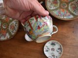 a person holding a cup and saucer on a table