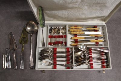 une boîte contenant de l'argenterie, posée par terre