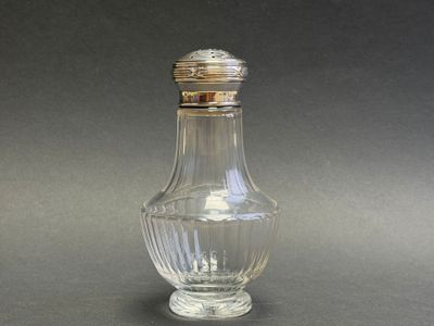a small glass bottle with a silver lid on a table
