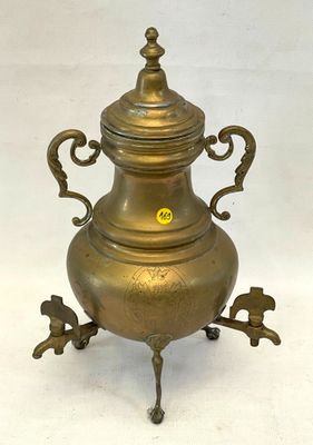 une urne ancienne en laiton, munie de deux anses et d'un couvercle, posée sur un socle