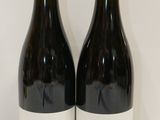 deux bouteilles de vin posées sur une table l'une à côté de l'autre