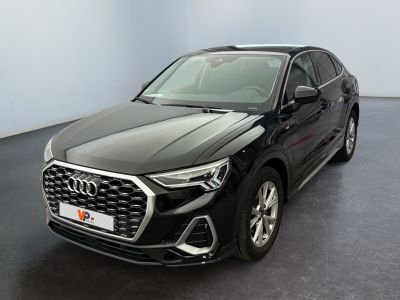une Audi QX noire garée dans une grande pièce