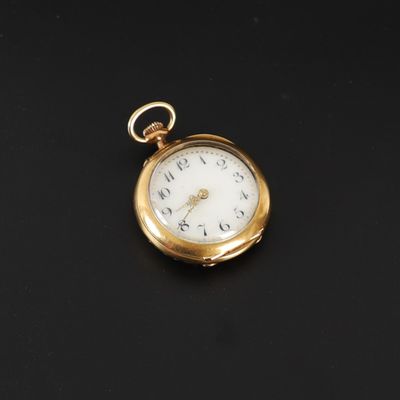 une image représentant une montre de poche en or posée sur une surface noire