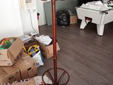 a brown coat stand in a room with boxes and a pool table