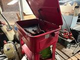 une glacière rouge posée sur une palette dans un garage