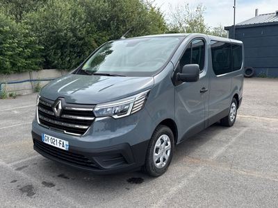 La camionnette grise est garée sur un parking près d'un immeuble.
