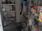 a small room with shelves and a refrigerator in it