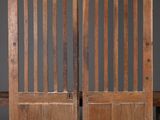 une paire de portes anciennes en bois avec des panneaux de vitraux et un banc
