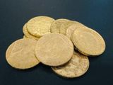 some gold coins are sitting on a black surface