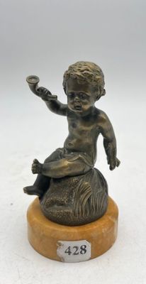 bronze statue of a boy sitting on a rock with a bird in his hand