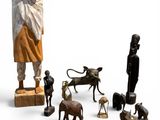 une statue représentant un homme debout à côté d'un groupe d'animaux