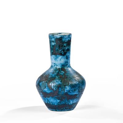 un vase bleu posé sur une surface blanche