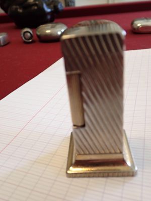 a silver lighter sitting on top of a piece of paper