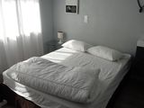 un lit recouvert d'une couette blanche et de draps blancs