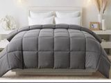 the comforter is gray and white in a bedroom with a white headboard