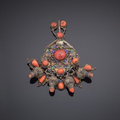 a close up of a broochee with coral and silver